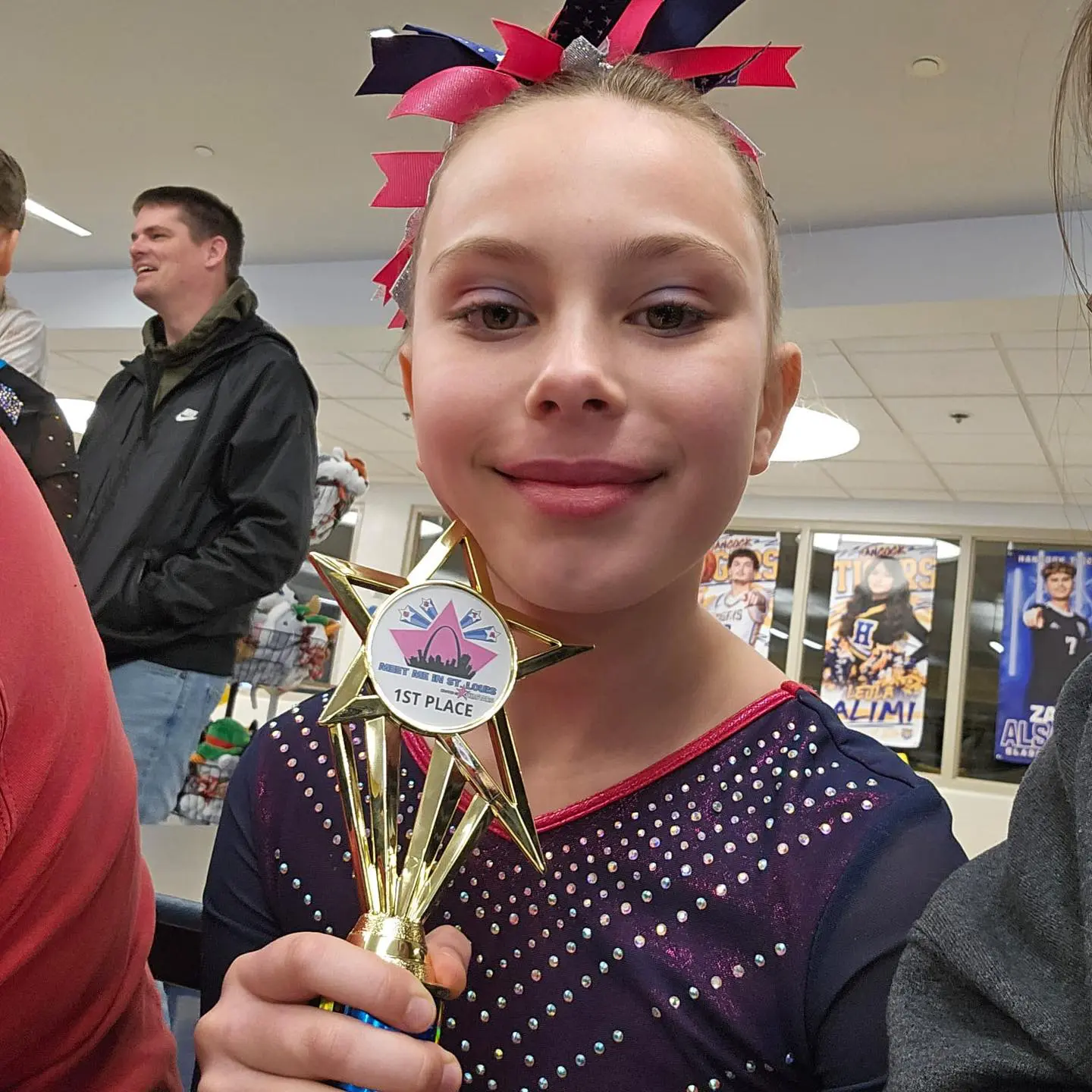 Smiling cheerleader holding first-place trophy