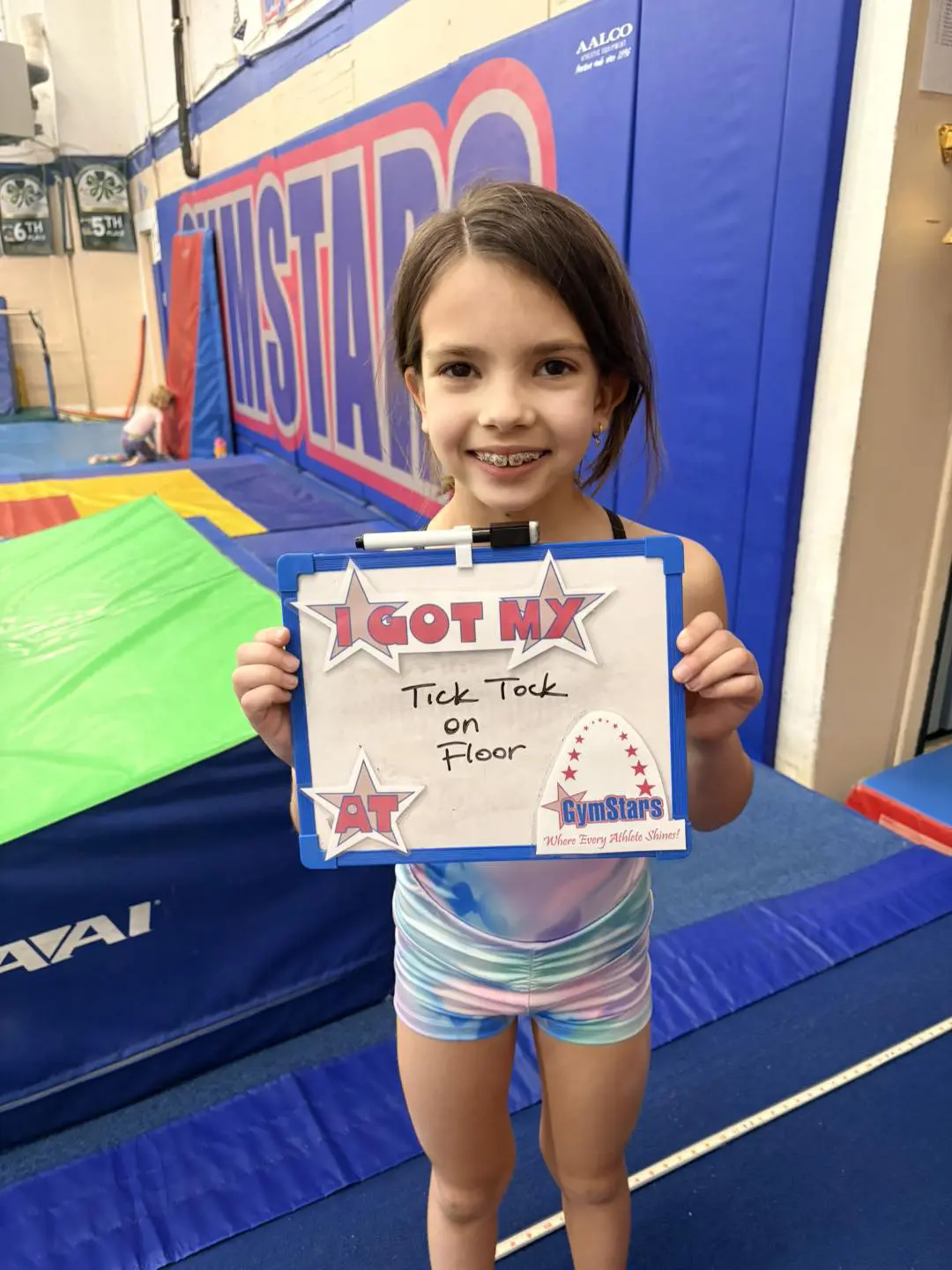 Young gymnast smiling with achievement sign