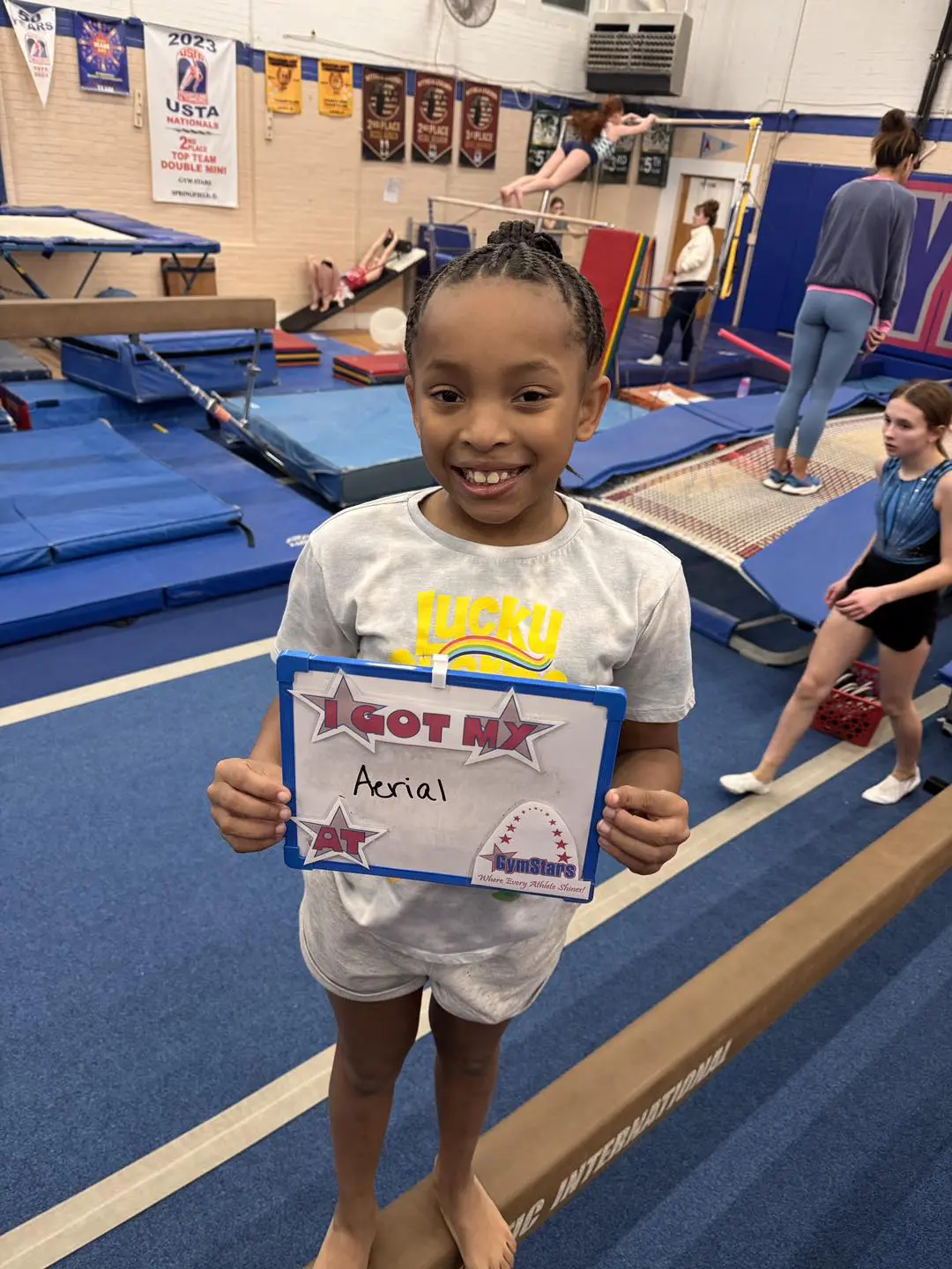 Smiling young gymnast holding aerial certificate