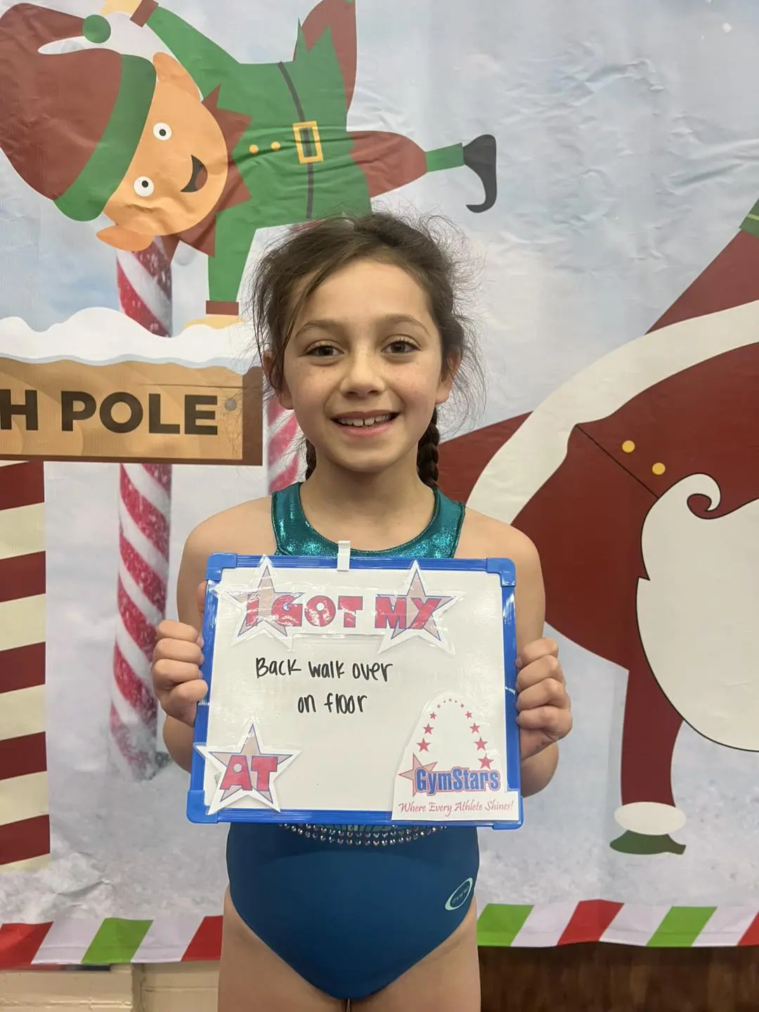 Smiling gymnast holding award sign