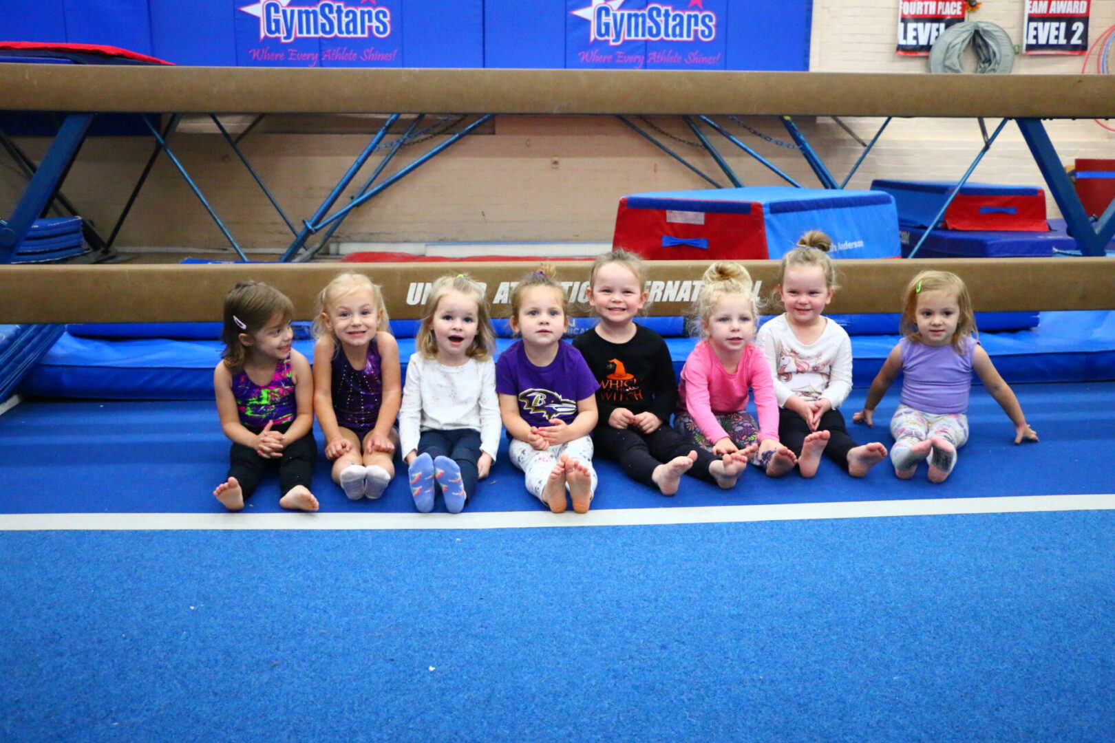 A group of young children sitting on the ground.