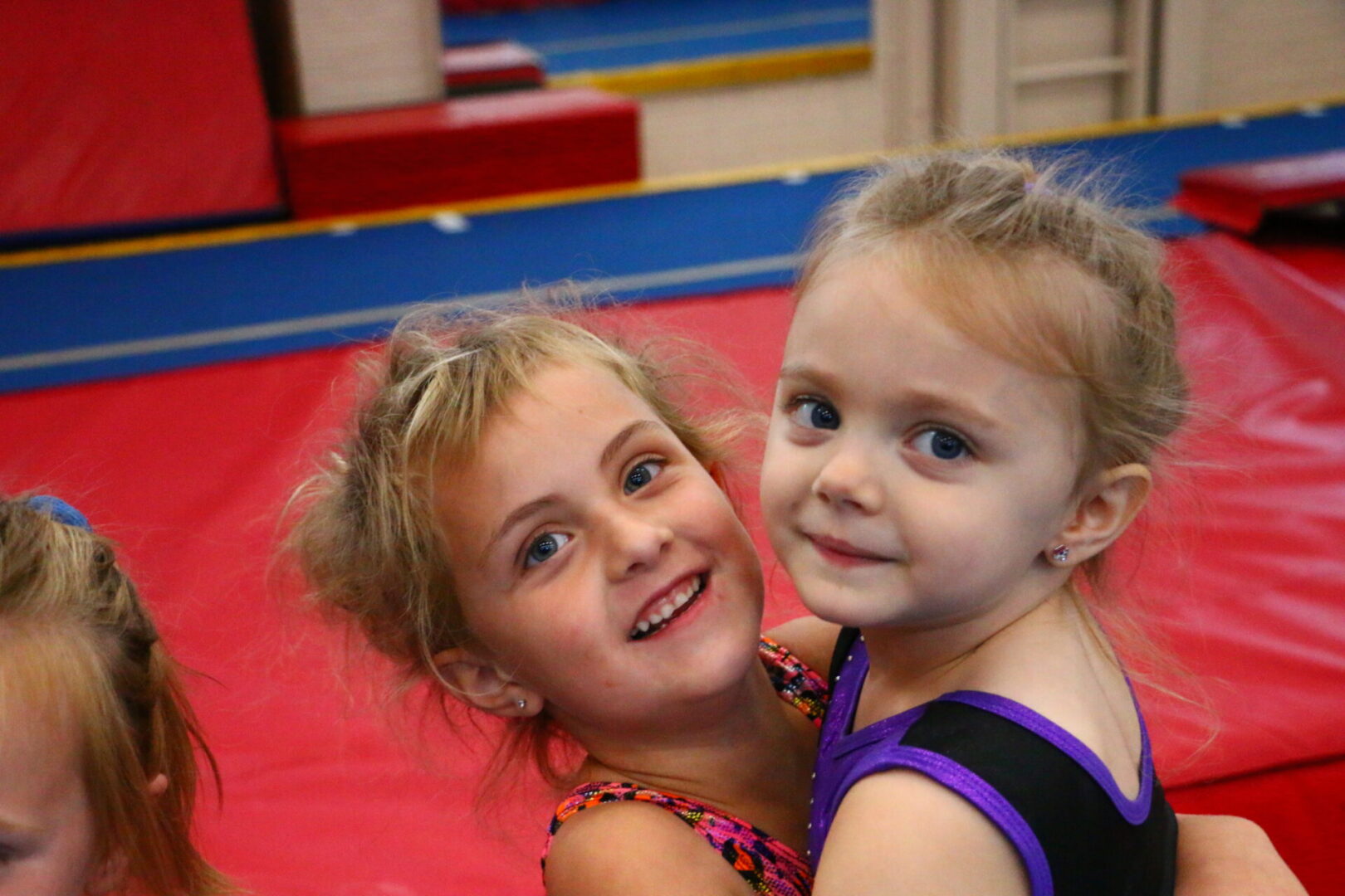 Two young girls posing for a picture in their gym clothes.